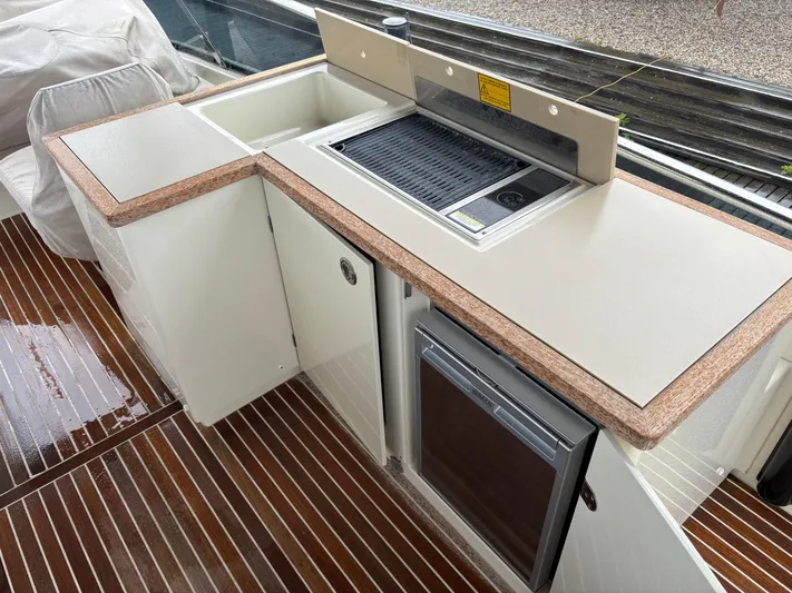  Yacht Photos Pics Outdoor kitchen on 2015 Beneteau Monte Carlo 6 yacht with grill and mini fridge.