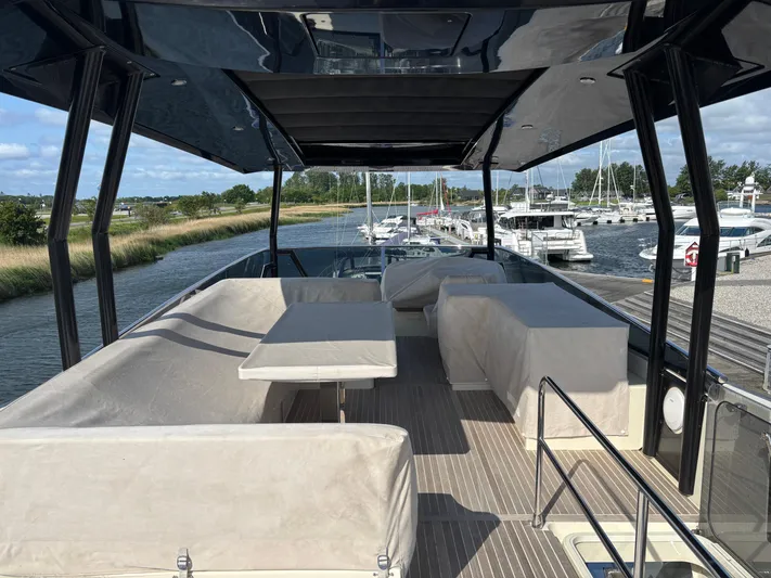  Yacht Photos Pics Flybridge of 2015 Beneteau Monte Carlo 6 yacht with seating and table, docked at marina.
