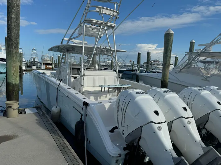  Yacht Photos Pics 2020 Invincible 40 Catamaran docked with triple outboard engines, clear sky background.