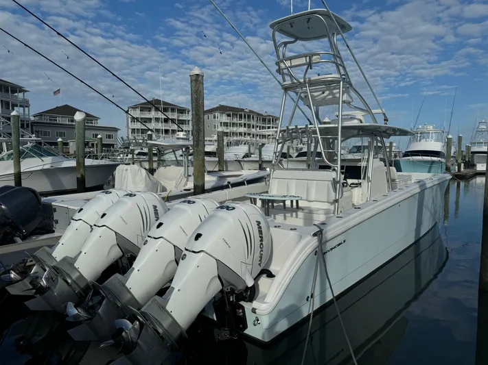  Yacht Photos Pics 2020 Invincible 40 Catamaran docked with triple outboard engines, under a partly cloudy sky.