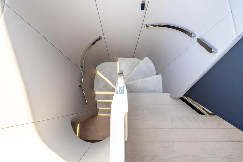 Second Chances Yacht Photos Pics Modern spiral staircase inside 2024 Azimut S7 yacht, featuring sleek design and elegant handrails.