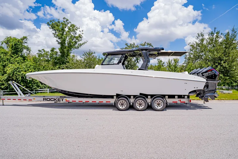  Yacht Photos Pics 2026 Fountain 38 SCX boat on trailer, parked outdoors under a blue sky.