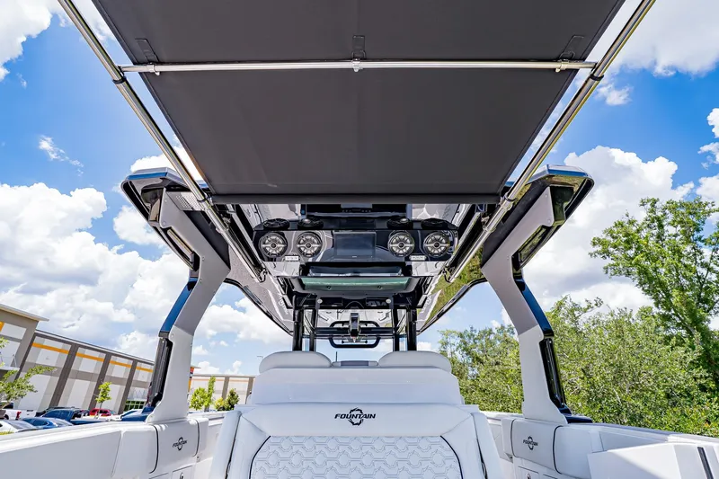  Yacht Photos Pics 2026 Fountain 38 SCX boat interior with canopy, speakers, and seating under a blue sky.