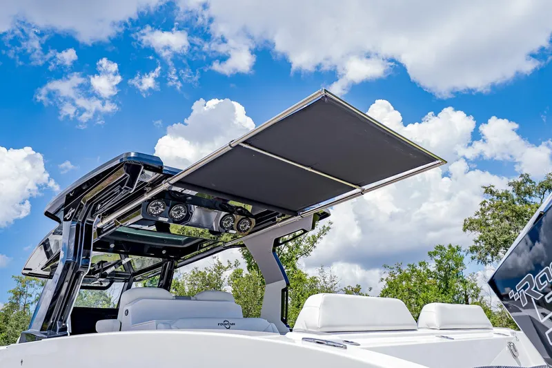  Yacht Photos Pics 2026 Fountain 38 SCX boat with sleek design and retractable canopy under a blue sky.