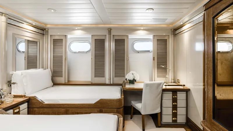 Olympus Yacht Photos Pics Luxurious cabin interior of a 1996 Feadship motor yacht with elegant furnishings and porthole windows.