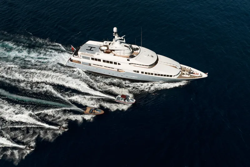 Olympus Yacht Photos Pics Aerial view of 1996 Feadship motor yacht with accompanying speedboats on open water.