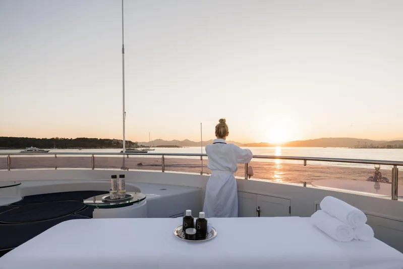 Olympus Yacht Photos Pics Luxury yacht deck at sunset, Feadship 1996 model, with person enjoying the view.
