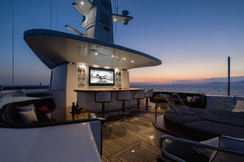 Olympus Yacht Photos Pics Luxurious 1996 Feadship motor yacht deck with bar and seating at sunset.