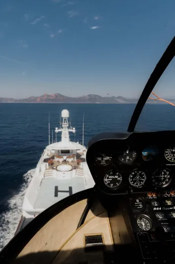 Olympus Yacht Photos Pics Helicopter view of 1996 Feadship motor yacht at sea, clear skies, distant mountains.
