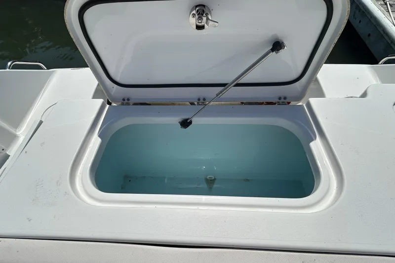  Yacht Photos Pics Open storage compartment on 2021 Sea Hunt Gamefish 25 boat, showing interior.