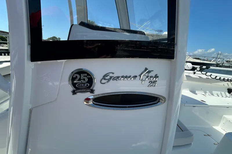 Yacht Photos Pics 2021 Sea Hunt Gamefish 25 boat with 25th anniversary emblem, docked under clear skies.