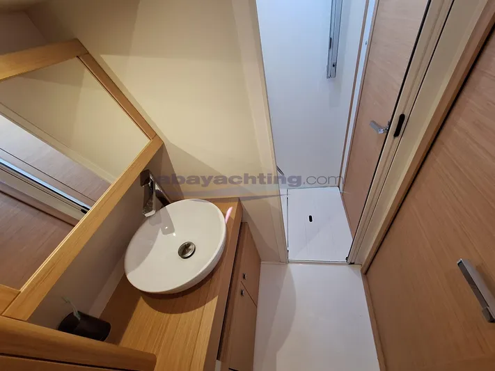  Yacht Photos Pics Bathroom interior of 2019 Grand Soleil 52 LC Sport yacht, featuring modern sink and wooden cabinetry.
