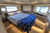 Luxurious bedroom interior of 2021 Absolute 52 Navetta yacht with elegant bedding.