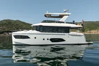 2021 Absolute 52 Navetta yacht on calm water with scenic hillside background.