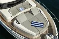Luxurious 2021 Absolute 52 Navetta yacht deck with sun loungers and striped towels.