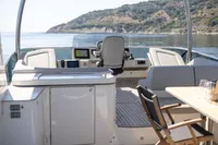 2021 Absolute 52 Navetta yacht interior with helm, seating, and scenic coastal view.