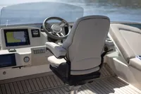 Captain's chair and dashboard of 2021 Absolute 52 Navetta yacht, featuring navigation screens.