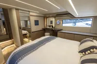 Luxurious bedroom interior of 2021 Absolute 52 Navetta yacht with elegant design and large window.