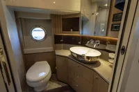 Luxurious bathroom in 2021 Absolute 52 Navetta yacht with modern fixtures and porthole window.