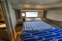 Luxurious bedroom interior of 2021 Absolute 52 Navetta yacht with nautical-themed bedding.