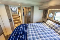Luxurious bedroom interior of 2021 Absolute 52 Navetta yacht with nautical decor.