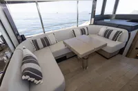 Luxurious interior of 2021 Absolute 52 Navetta yacht with cozy seating and ocean view.