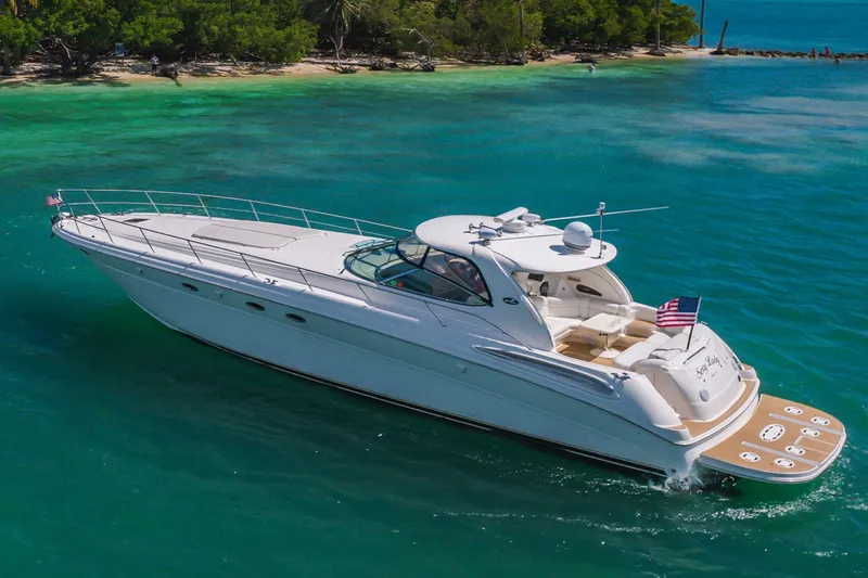  Yacht Photos Pics 2002 Sea Ray 510 Sundancer yacht cruising in turquoise waters near a lush shoreline.