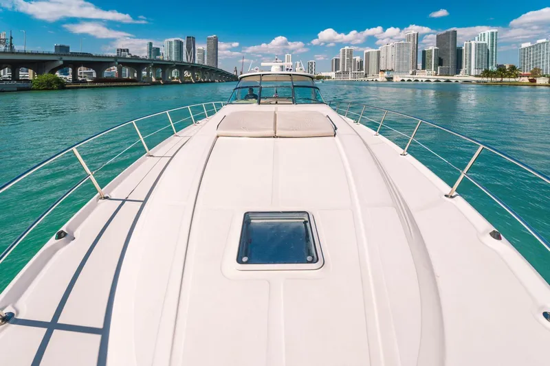  Yacht Photos Pics 2002 Sea Ray 510 Sundancer yacht cruising near city skyline and bridge.