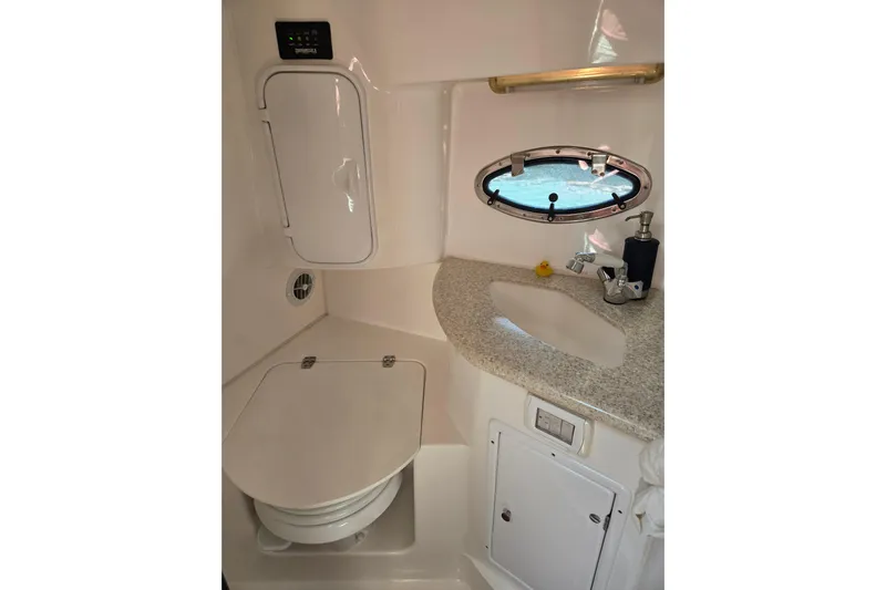 Let's Go! Yacht Photos Pics 2007 Fountain 38 Express Cruiser bathroom with sink, toilet, and porthole window.