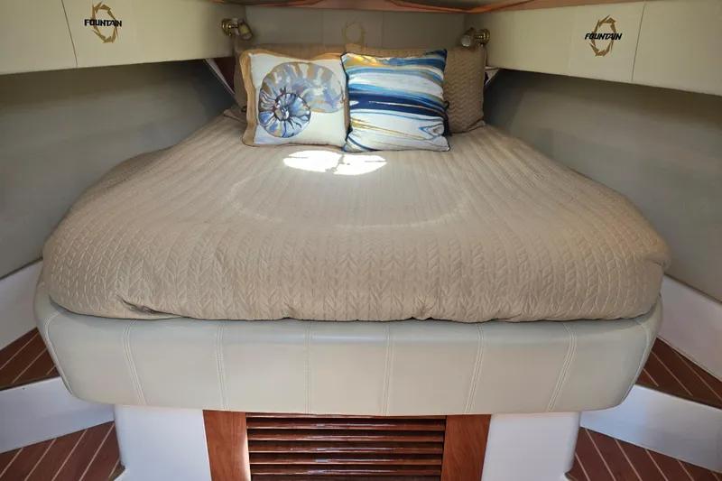 Let's Go! Yacht Photos Pics 2007 Fountain 38 Express Cruiser cabin with cozy bed and decorative pillows.