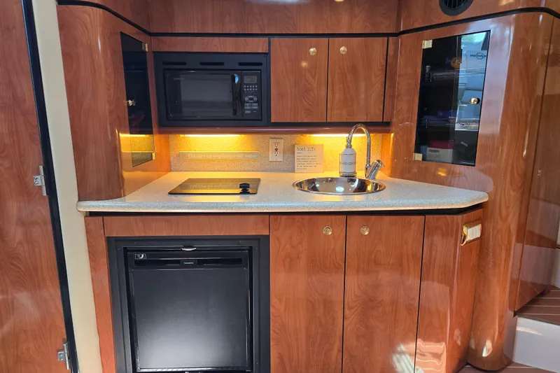 Let's Go! Yacht Photos Pics 2007 Fountain 38 Express Cruiser interior kitchen with wood cabinets, sink, and appliances.