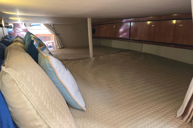 Let's Go! Yacht Photos Pics 2007 Fountain 38 Express Cruiser cabin with cozy bedding and wooden storage cabinets.