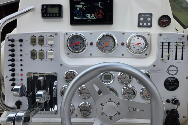 Let's Go! Yacht Photos Pics Control panel of a 2007 Fountain 38 Express Cruiser with gauges and steering wheel.