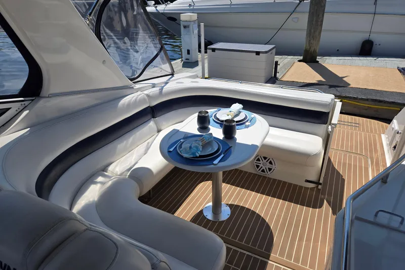 Let's Go! Yacht Photos Pics Luxurious 2007 Fountain 38 Express Cruiser with elegant seating and dining setup on deck.