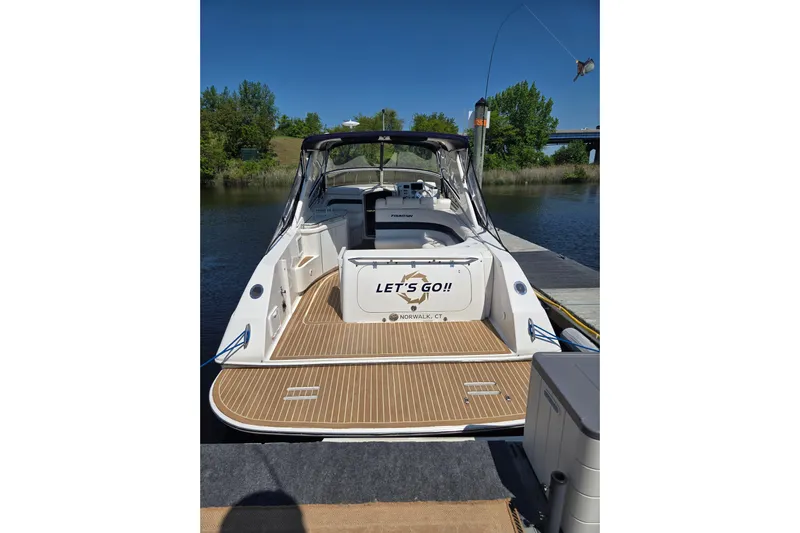 Let's Go! Yacht Photos Pics 2007 Fountain 38 Express Cruiser docked by a serene river, ready for adventure.