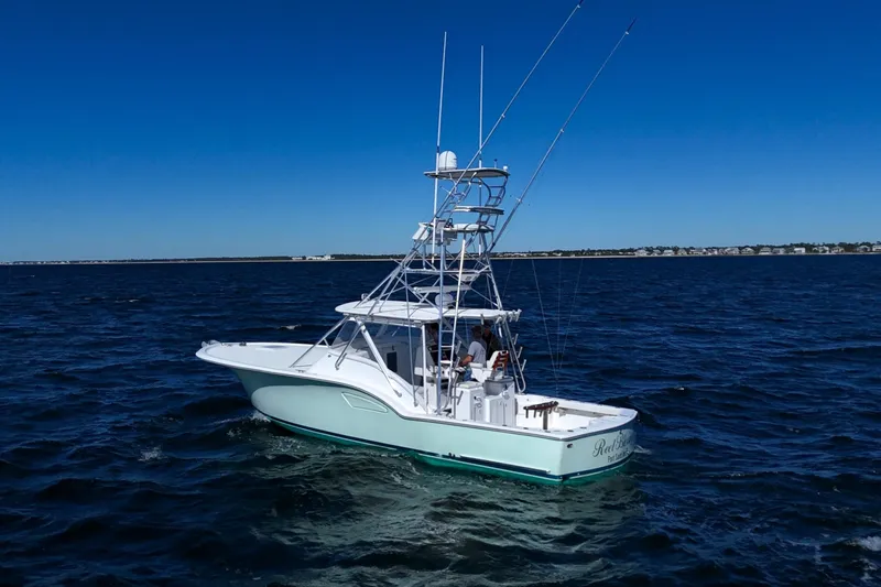 Reel Blessings Yacht Photos Pics 2006 Out Island 38 Express boat cruising on open water under clear blue sky.