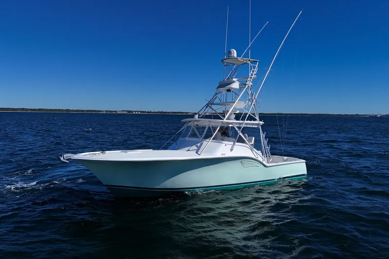 Reel Blessings Yacht Photos Pics 2006 Out Island 38 Express boat cruising on open water under clear blue sky.