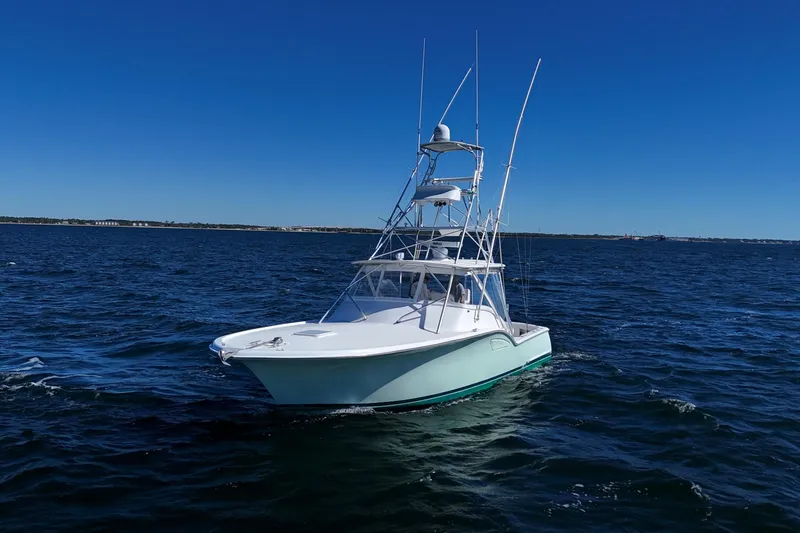 Reel Blessings Yacht Photos Pics 2006 Out Island 38 Express boat cruising on open water under clear blue sky.