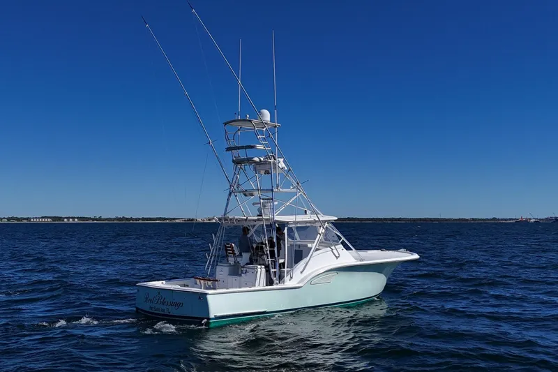 Reel Blessings Yacht Photos Pics 2006 Out Island 38 Express boat cruising on open water under clear blue sky.