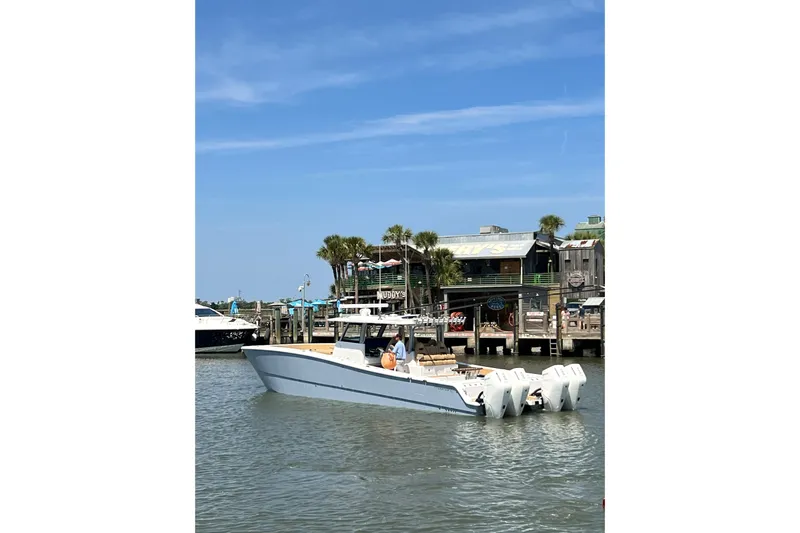 Lafe Yacht Photos Pics 2026 Freeman 47 boat docked near waterfront restaurant, clear blue sky.