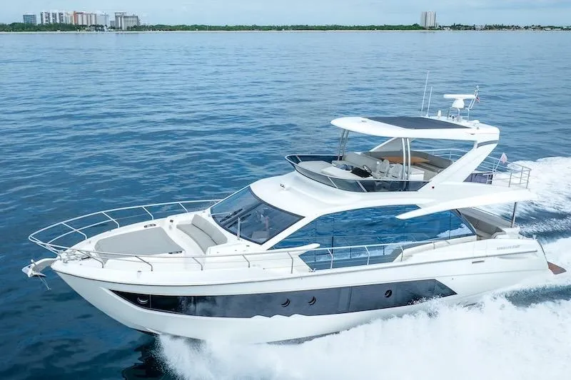  Yacht Photos Pics 2023 Absolute 62 Fly yacht cruising on open water, showcasing sleek design and luxury features.