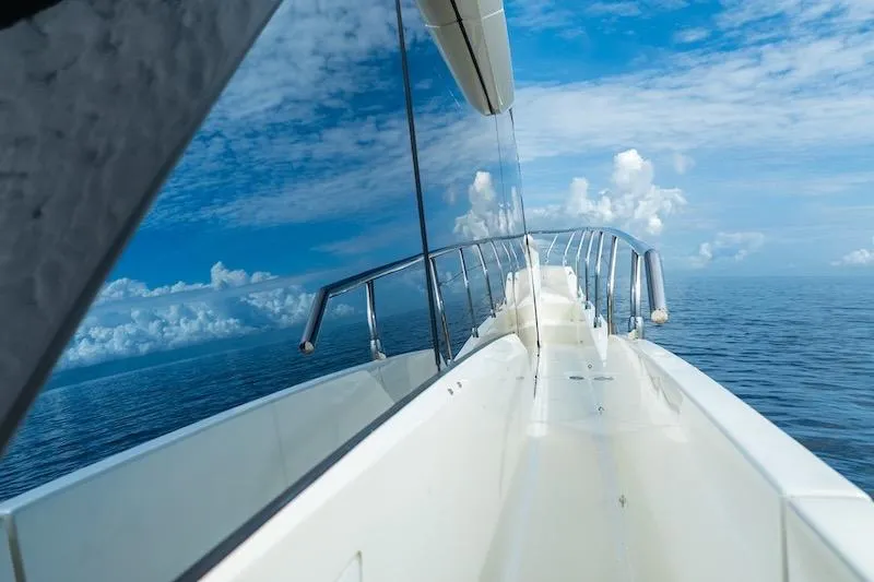  Yacht Photos Pics 2023 Absolute 62 Fly yacht reflecting ocean and sky, showcasing sleek design.