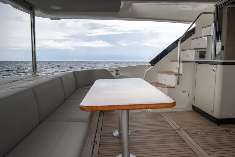  Yacht Photos Pics Luxurious 2023 Absolute 62 Fly yacht deck with seating, table, and ocean view.