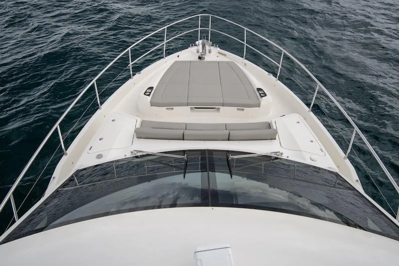  Yacht Photos Pics 2023 Absolute 62 Fly yacht bow view with sunpad, cruising on open water.