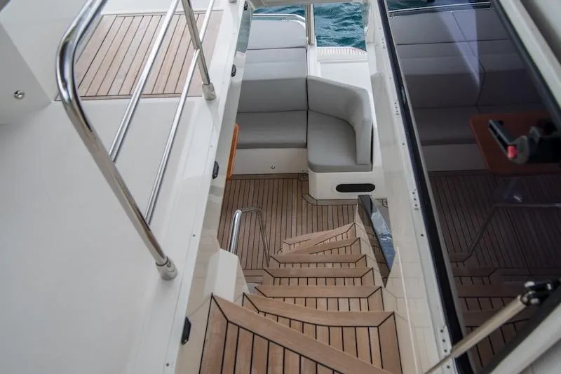  Yacht Photos Pics Luxurious 2023 Absolute 62 Fly yacht interior with wooden stairs and seating area.