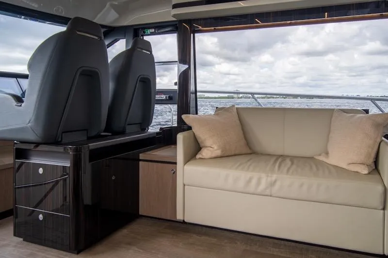  Yacht Photos Pics Luxurious interior of 2023 Absolute 62 Fly yacht with sofa and helm seats.