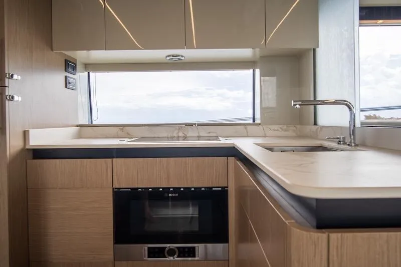 Yacht Photos Pics Modern kitchen interior of 2023 Absolute 62 Fly yacht with sleek cabinetry and appliances.