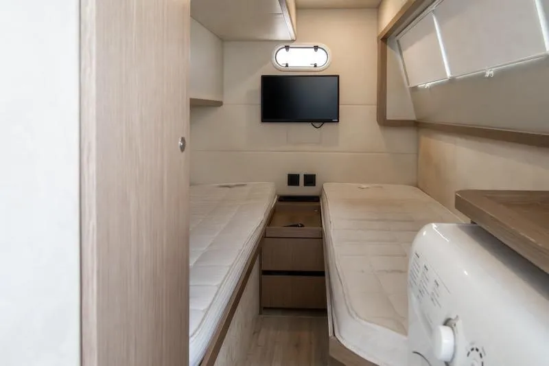  Yacht Photos Pics 2023 Absolute 62 Fly yacht cabin with twin beds, TV, and modern decor.