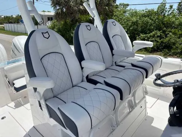 Black Label Marine Yacht Photos Pics 2025 Sea Fox 328 Commander boat seats with white quilted upholstery and armrests.