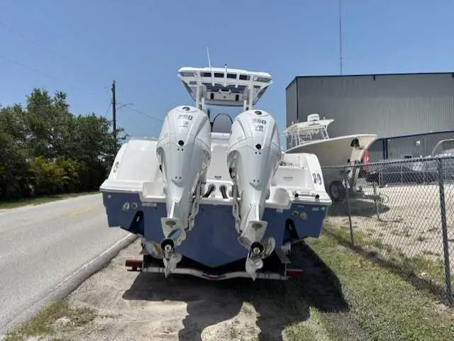 Black Label Marine Yacht Photos Pics 2025 Sea Fox 328 Commander boat with dual engines, parked near a fence.